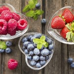 Mix of fresh berries in three  glass ramekins in shape of heart,